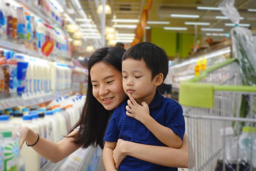 Mom and child shop for milk at grocery store