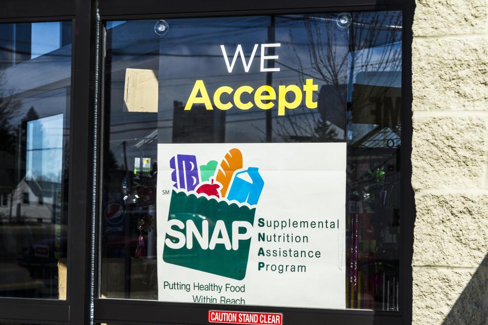 Sign in store window that reads, "We accept SNAP"