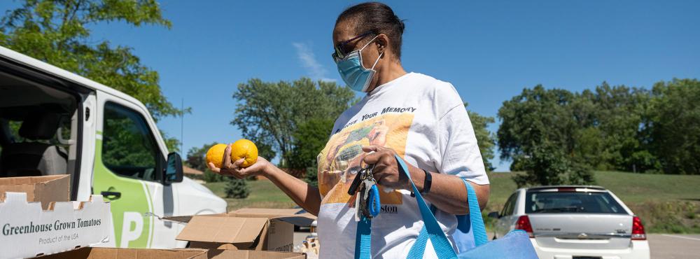 Woman holds oranges at food distribution