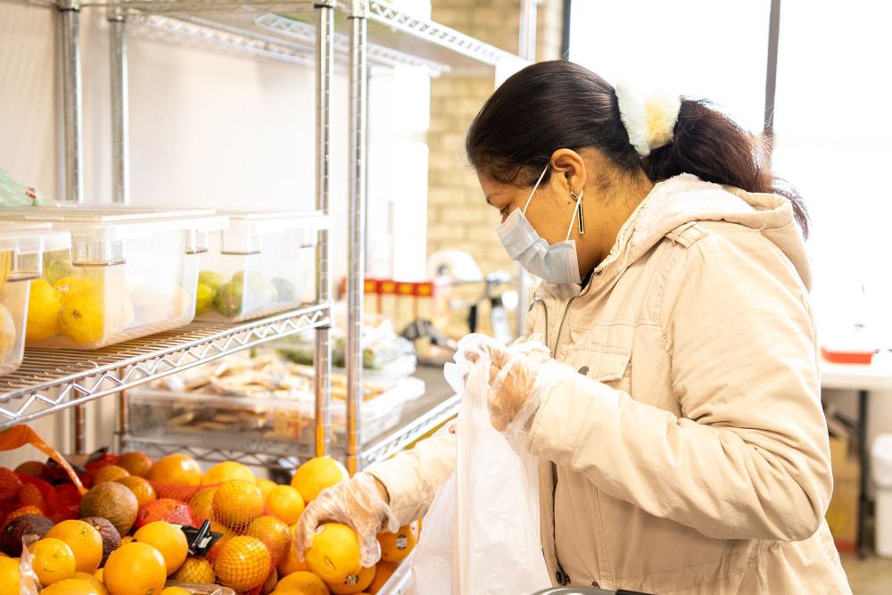 A woman shops for produce at food shelf