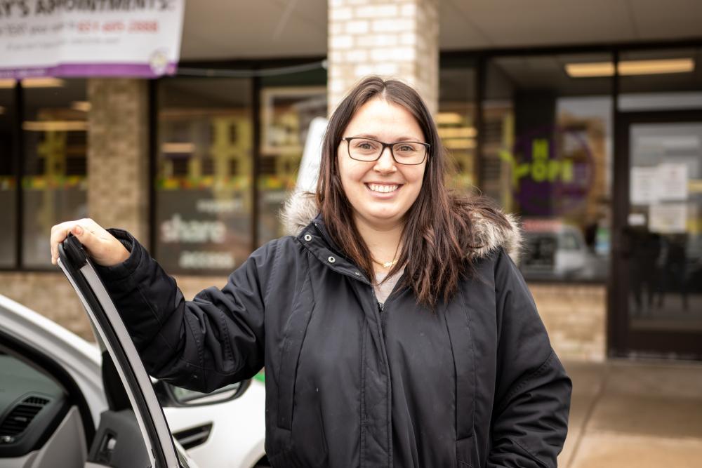 woman standing in front of food shelf smiling 