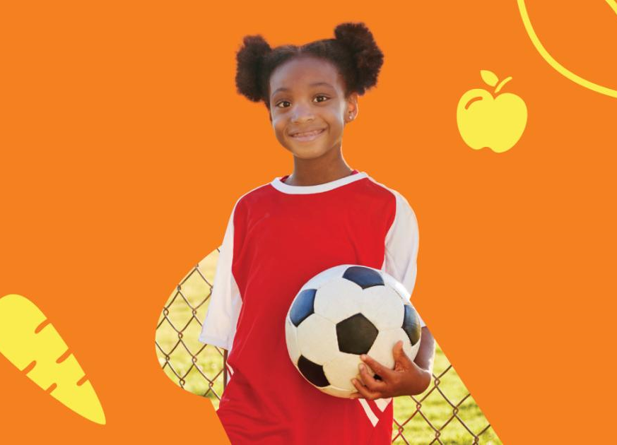 A little girl holding a soccer ball in front of an orange back-drop