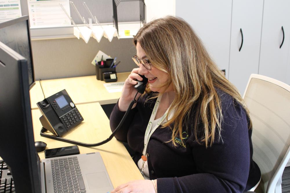 Desiree Olson, a Strategic Partners Supervisor, on the phone in her office
