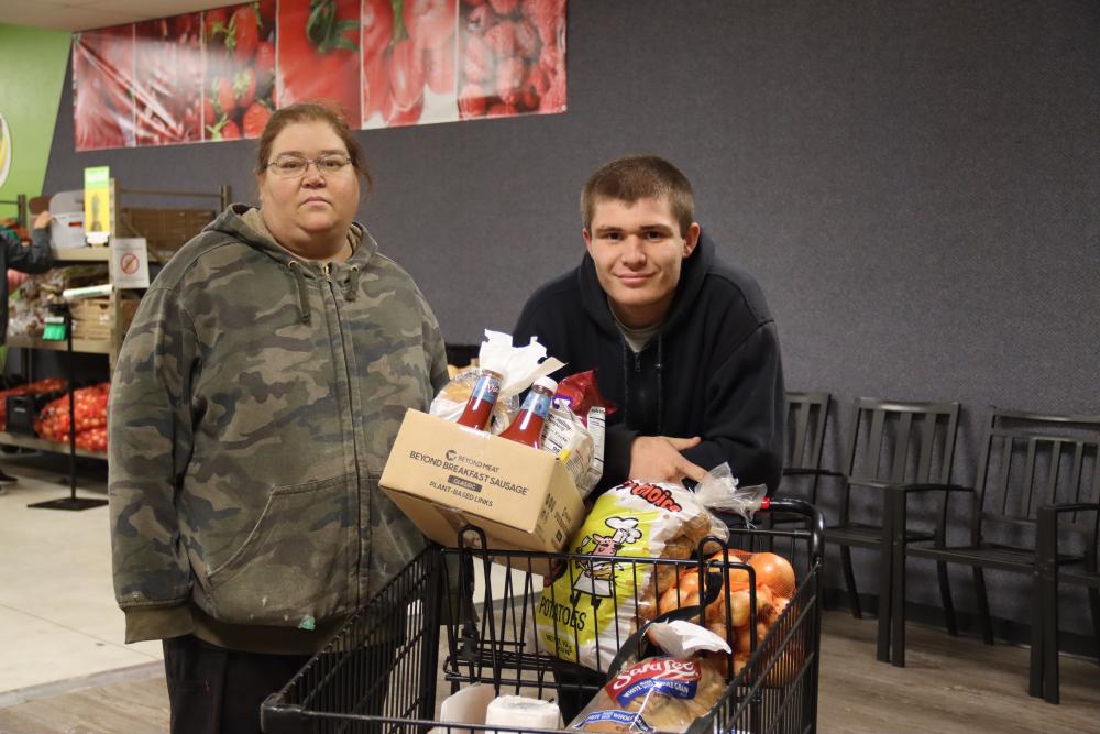 A mother and son shop for groceries