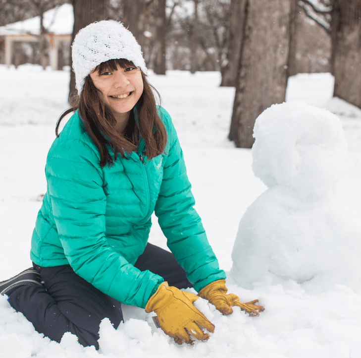 Girl building snowman