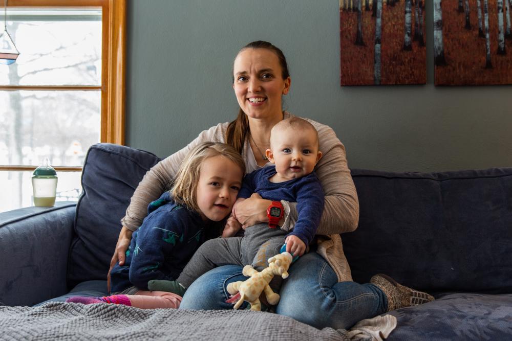 A woman and two children sitting on a couch