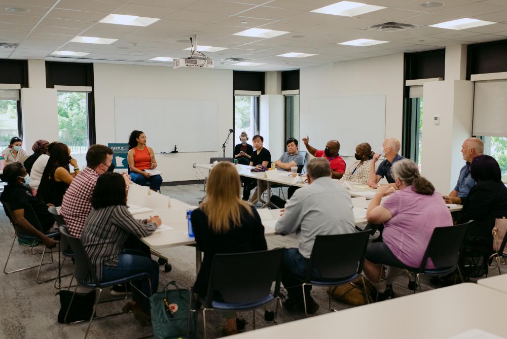 A group of people sit around a large conference table.