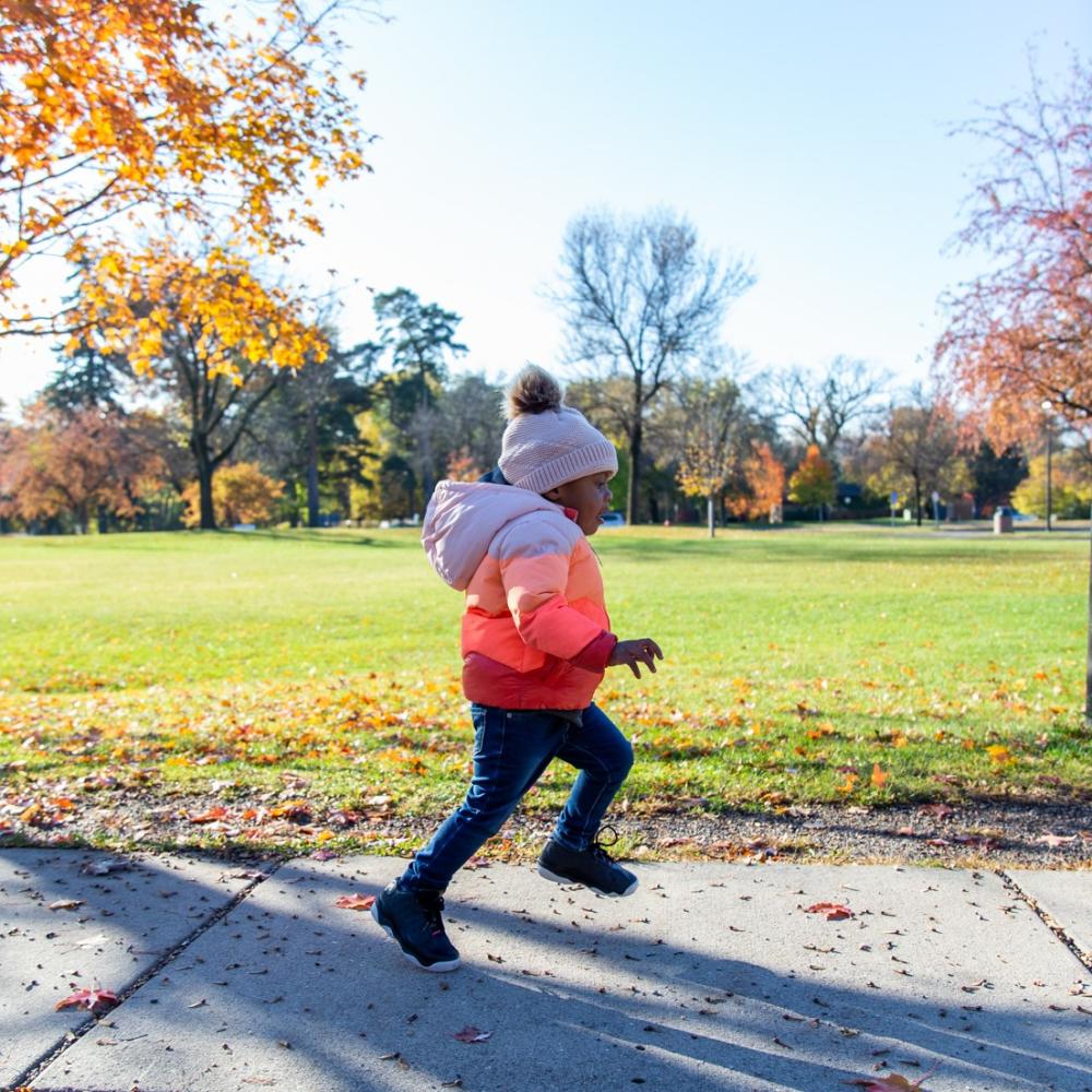 A child running on a sidewalk outdoors
