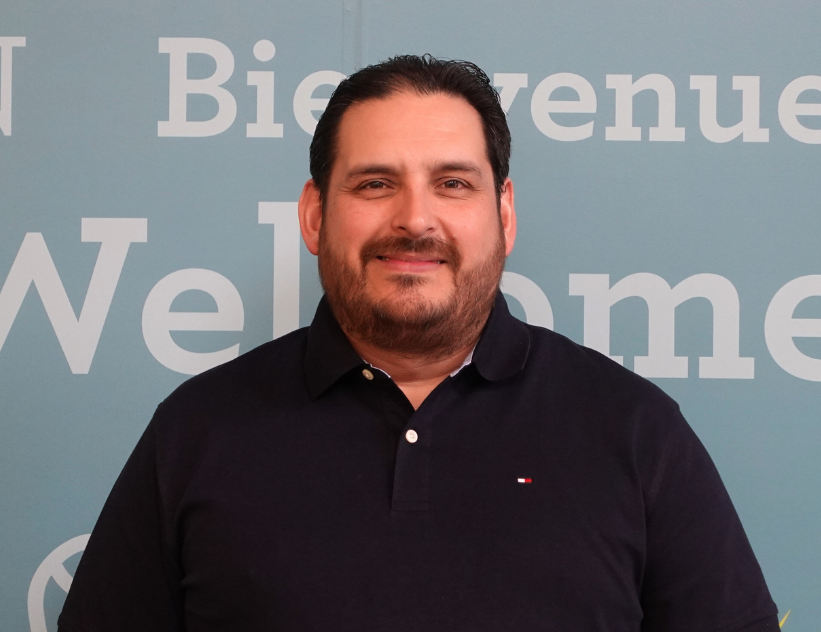 An employee in a polo shirt poses for a portrait