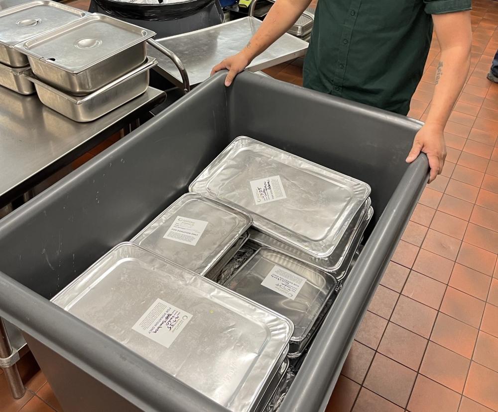 St Paul Public Schools Prepared Food Donation Person pushing cart of foil-covered pans of food