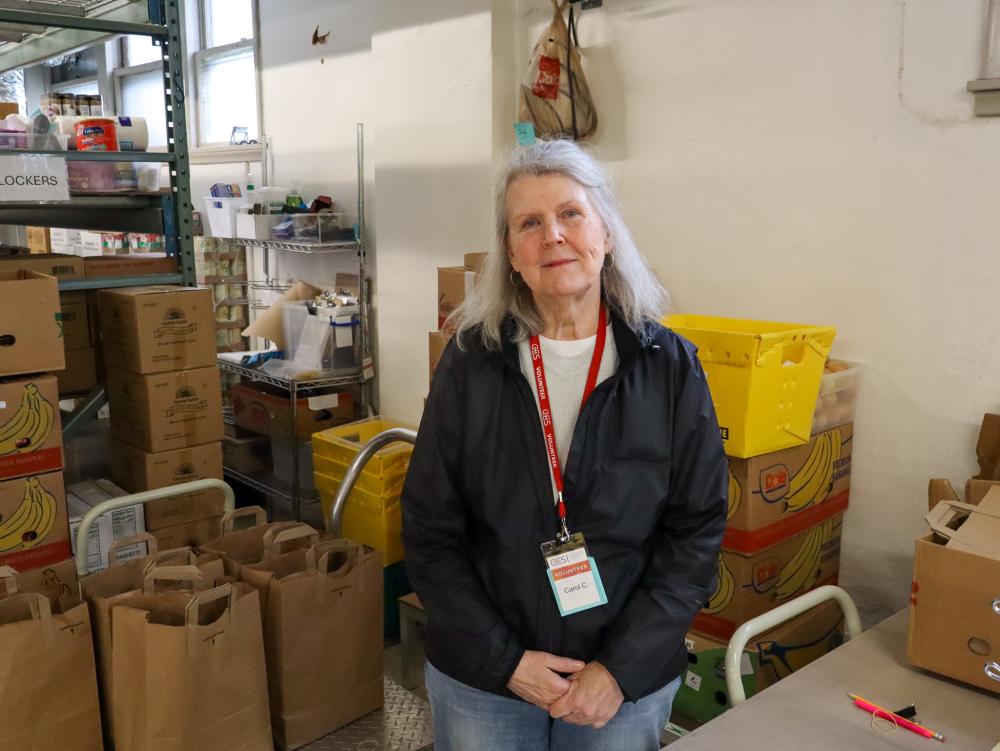 A volunteer fills grocery bags at a food shelf
