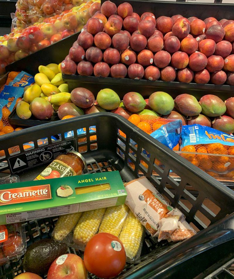 Fresh produce and grocery cart Cart in produce section of grocery store with pasta, sauce, produce and lentils in it