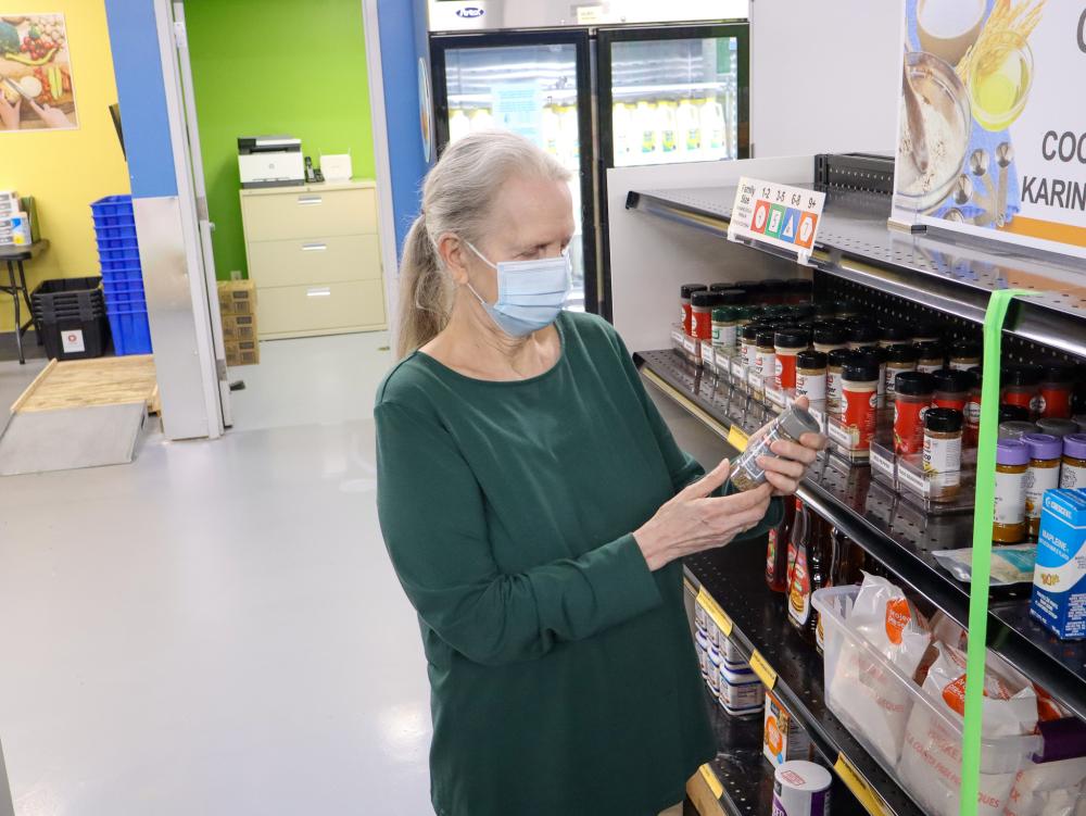 A woman in a face mask shops for spices