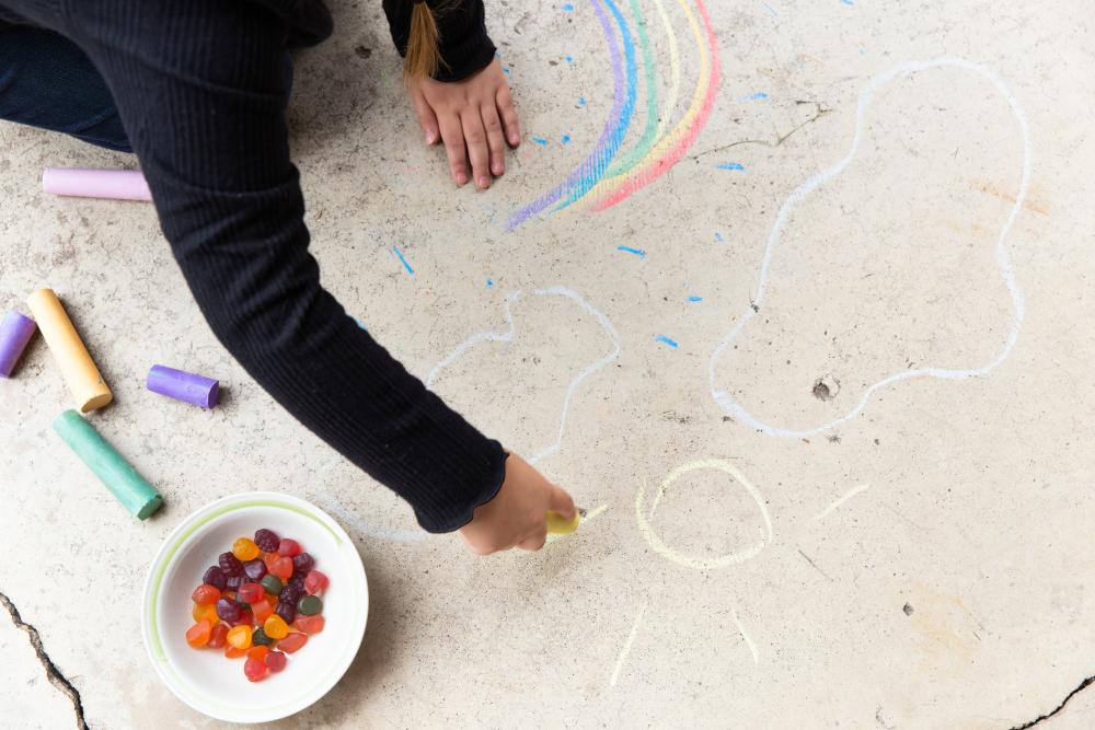 Kid writing with chalk on a sidewalk