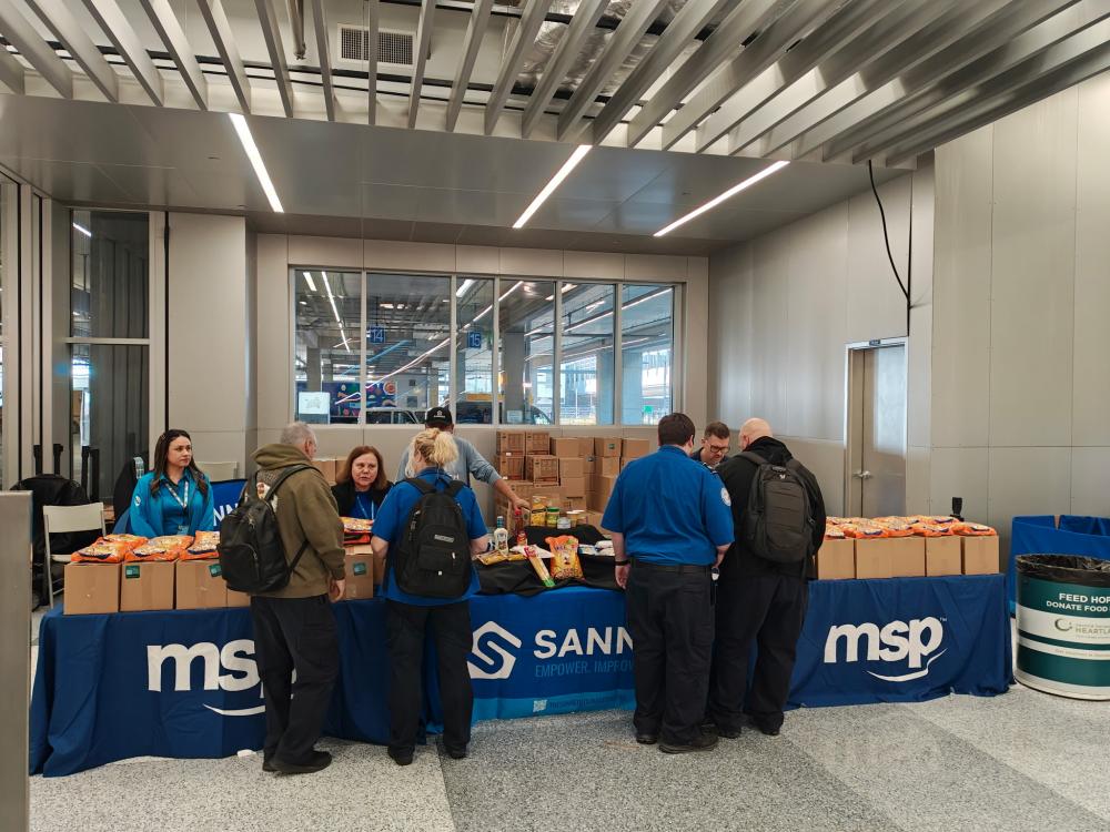 People in front of table full of emergency boxes of food