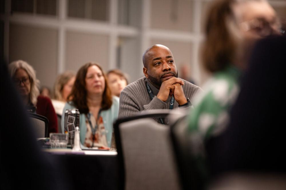 Summit attendee listening to a speaker