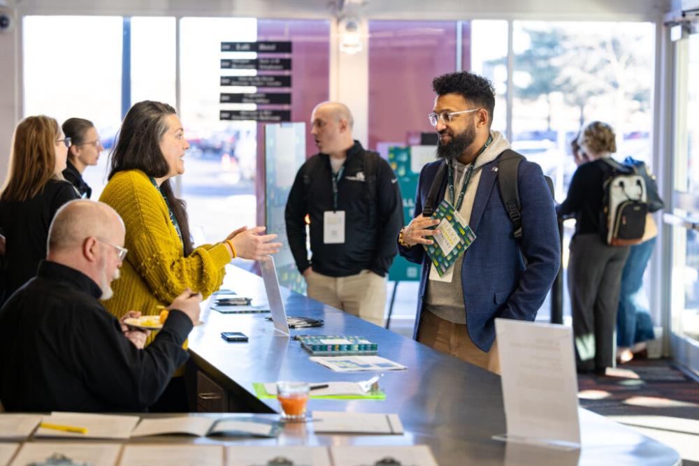 Two people talking at a registration desk
