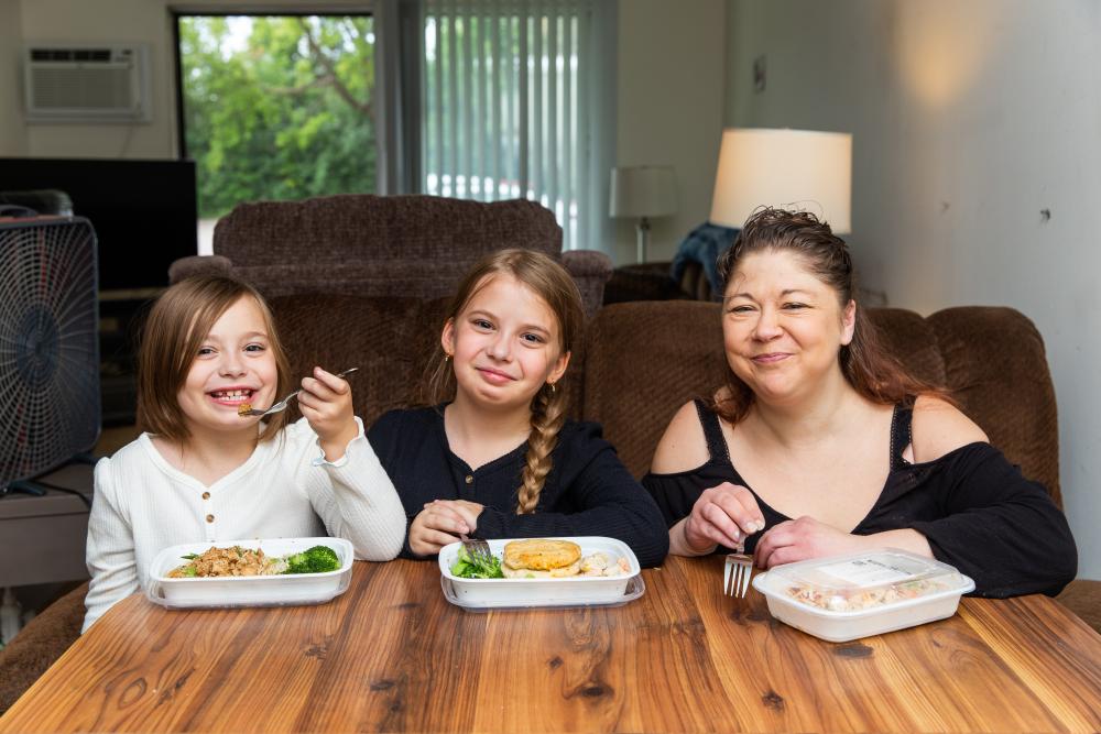 Three kids eating a meal at a table