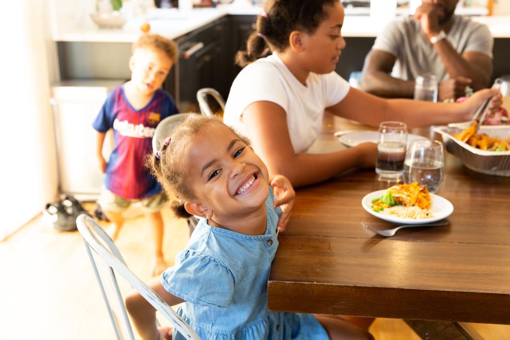 Child smiling while seated at a dining table