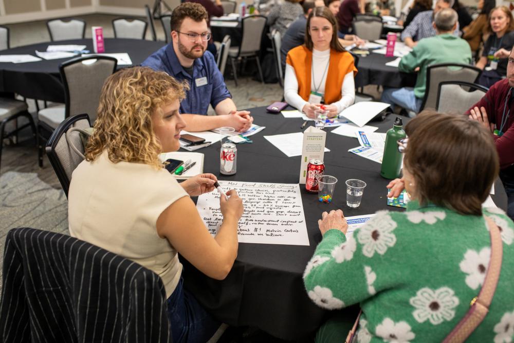 Attendees doing an activity at a table during a breakout session