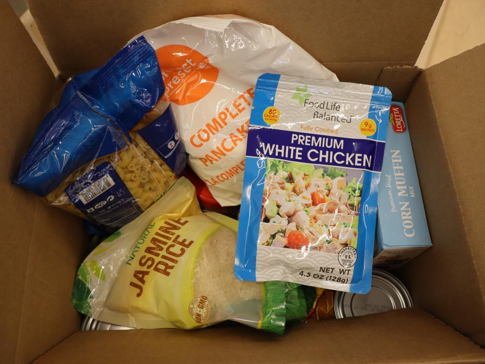 Box filled with food like pasta, rice and chicken