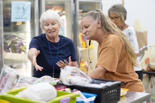 An older woman getting help shopping at a food shelf
