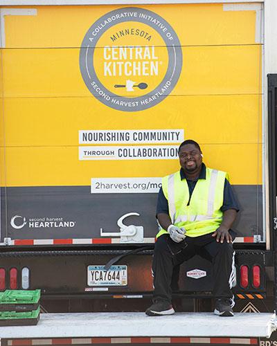 Driver sitting on the tailgate of the MCK delivery truck