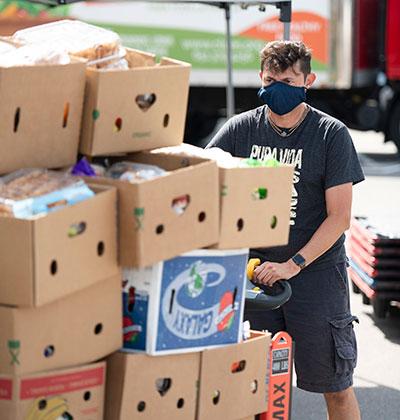 A man pushes a forklift full of boxes of food