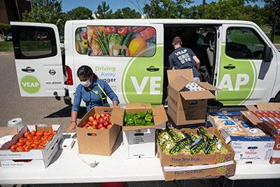 Food distribution table full of food with van in the background