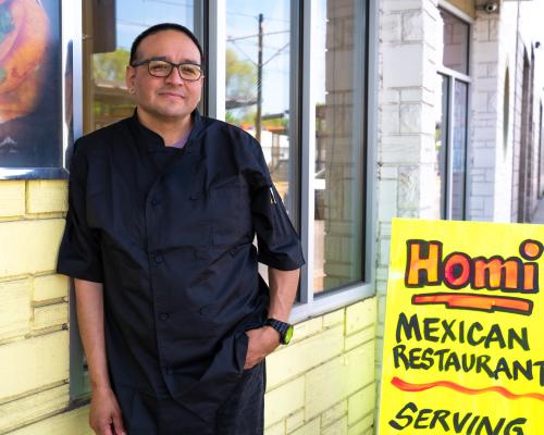 Chef Miguel Lopez standing in front of restaurant