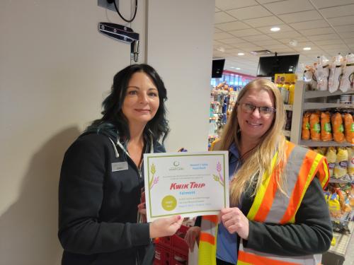 A Kwik Trip employee presents a certificate to a partner.
