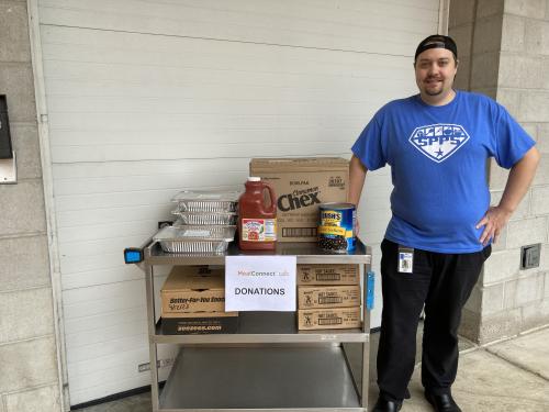 A St. Paul Public Schools employee poses with a cart of food donations