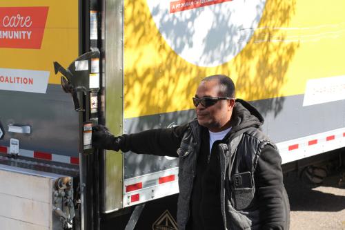 A man in sunglasses stands by a Kitchen Coalition truck