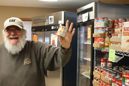 A volunteer shows off a canned good