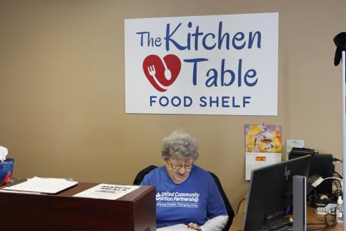 A volunteer does intake at a food shelf