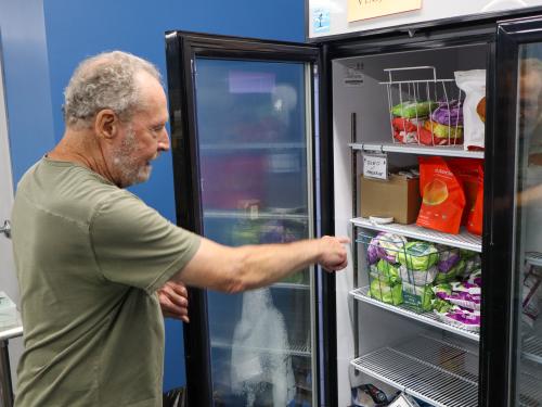 Duane at St. Peter Area Food Shelf Duane pointing things out in the fridge at the food shelf.
