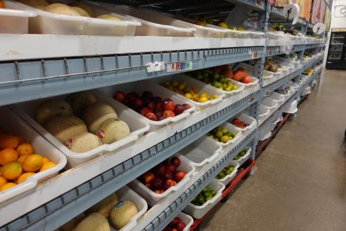 Bins of produce on three layers of gray shelves