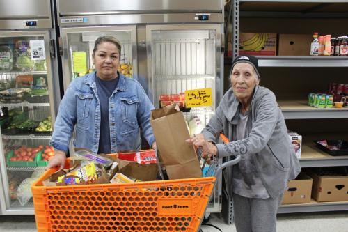 Yvette and Carola at Hasting Family Service Yvette and Carola with a shopping cart full of food at Hasting Family Service