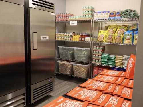 Photo of a food shelf with veggies in a fridge and can goods on a shelf